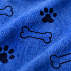 Detalle del estampado de huesos y huellas sobre la microfibra azul real de la toalla Calmora